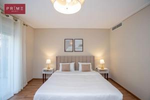 sypialnia z dużym białym łóżkiem i 2 lampami w obiekcie Prime Select New Giza w mieście Giza
