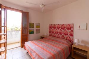 una camera da letto con un letto e una grande finestra di Rainbow Apartment - Torre dell'orso a Torre dell'Orso