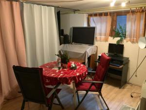 a room with a table and chairs and a television at Schöne Wohnung mit Balkon Non-Smoking in Klosterlechfeld