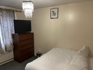 a bedroom with a bed and a television on a dresser at Henderson court in London