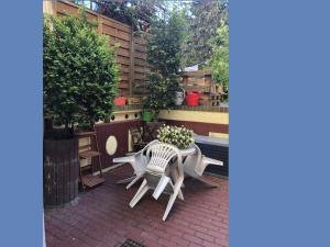 eine Terrasse mit einem Tisch, Stühlen und Blumen in der Unterkunft Gästezimmer Sprenger - Objekt 25985 in Rostock