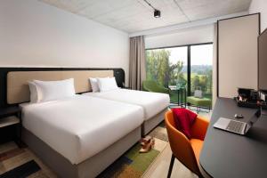 pokój hotelowy z łóżkiem, biurkiem i krzesłem w obiekcie Hyatt Place Krakow w Krakowie