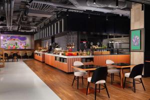 a kitchen with tables and chairs in a restaurant at Hyatt Place Krakow in Krakow