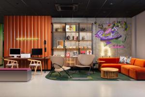salon z pomarańczową kanapą i krzesłami w obiekcie Hyatt Place Krakow w Krakowie