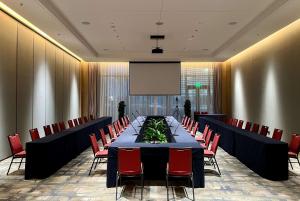 une salle de conférence avec une grande table et des chaises rouges dans l'établissement Wyndham Shanxi Xiaohe Xincheng, à Taiyuan