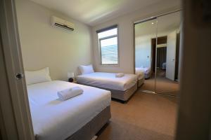 a hotel room with two beds and a mirror at Central Shepparton Apartments in Shepparton