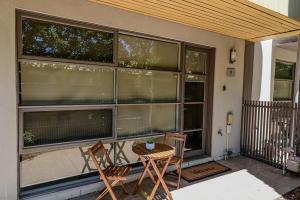 a patio with two chairs and a table in front of windows at Central Shepparton Apartments in Shepparton