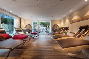un salón con sillas y mesas en una habitación en Bayern Resort - Apartments & Wellness, en Grainau