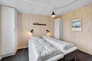 a bed in a room with wooden walls at Lalandia Søndervig in Søndervig