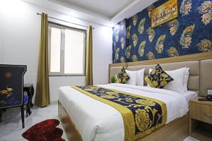 una camera da letto con un grande letto con una coperta blu e gialla di Hotel Decent Suites - Delhi Airport a Nuova Delhi