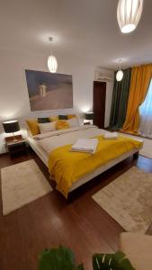 a large bedroom with a large bed with yellow sheets at Ambiennt in Bucharest