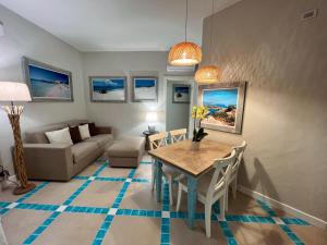 uma sala de estar com uma mesa e um sofá em Villa Aquamarina Pavoncella Rossa em Porto Pino
