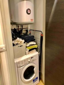 a laundry room with a washing machine and a microwave at Cheviot House in London