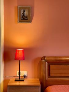 a lamp on a table next to a bed at Lefkandi Family House in Chalkida