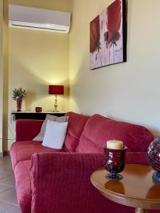 un sofá rojo en una sala de estar con mesa en Lefkandi Family House, en Chalkida