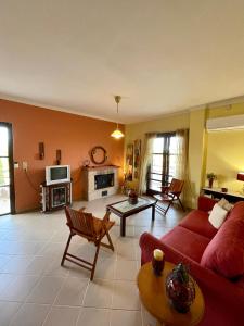 Lefkandi Family House في خالكيذا: غرفة معيشة مع أريكة حمراء وطاولة