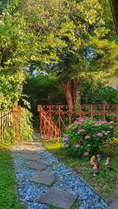 um jardim com uma cerca e um caminho com flores em Hiška pri Tisi em Ptujska Gora