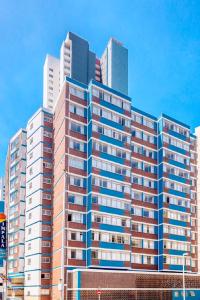 ein großes Apartmenthaus mit hohen Gebäuden im Hintergrund in der Unterkunft Impala Holiday Flats & Apartments in Durban