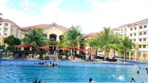 a group of people in the swimming pool at a resort at 2BR Casa Mia Sanremo Oasis Cebu in Talisay