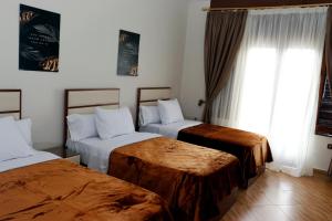 a hotel room with two beds and a window at Ismailia House Inn in Cairo +13 photos