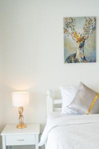 a bedroom with a bed and a deer painting on the wall at Kata Seaview Jacuzzi Suite - Pasifora in Kata Beach