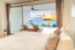 a bedroom with a bed with a view of the ocean at Kata Seaview Jacuzzi Suite - Pasifora in Kata Beach