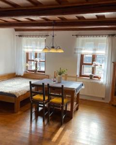 a dining room with a table and chairs and a bed at Chaloupka pod hradem in Svojanov