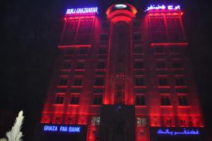 un edificio iluminado en rojo y azul en The Burj Ghazanfar in Mazar-e Sharif, 