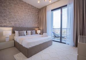a bedroom with a large bed and a large window at Nasma Luxury Stays- Ras Al Khaimah in Ras al Khaimah
