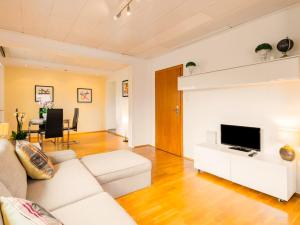ein Wohnzimmer mit einem weißen Sofa und einem TV in der Unterkunft Messewohnung Düsseldorf - Neuss in Neuss