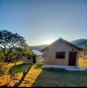 a small house in the middle of a field at Chalés de Hórus in São Thomé das Letras