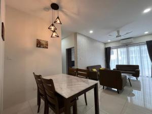 a dining room and living room with a table and chairs at Homestay P residence 3 bedroom and 2 bathroom in Kuching