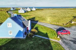 an aerial view of a house with a car parked in front at Gemütliches Cottage mit atemberaubender Aussicht in An Geata Mór