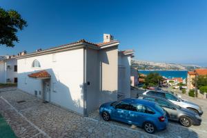 a small blue car parked next to a building at Apartments Crnekovic I Zarok in Ba&scaron;ka