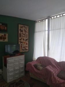 1 dormitorio con 1 cama y vestidor con TV en La casita de Calamuchita en Los Reartes