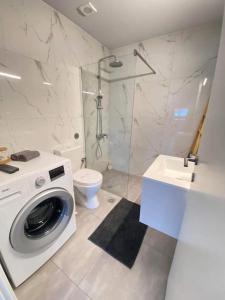 een badkamer met een wasmachine en een toilet bij DiFan Sea Homes A4 in Verga Kalamata