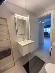 een witte badkamer met een wastafel en een spiegel bij DiFan Sea Homes A4 in Verga Kalamata