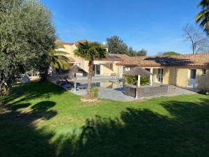 een huis met een tuin met een zwembad en bomen bij Escapade de luxe - Superbe villa avec piscine à 25mn des plages in Vergèze