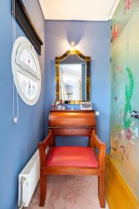 a red bench in a blue room with a mirror at Villa serenity in Kymi