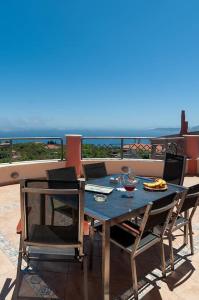 a blue table and chairs on a balcony with the ocean at Villa serenity in Kymi