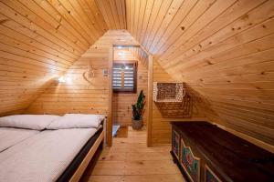 ein Schlafzimmer mit einem Bett in einer Holzhütte in der Unterkunft Lunela estate with sauna in Cerklje na Gorenjskem