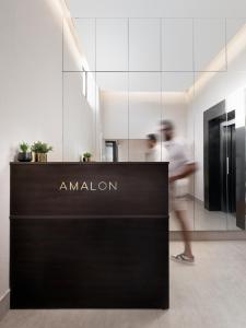 エルサレムにあるAMALON Boutique Apartmentsの建物内の展示物を通り過ぎて歩いている男