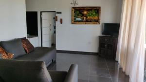 Una sala de estar con un sofá y un televisor. en Whalers Retreat, en Bettyʼs Bay