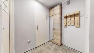 a hallway with white walls and a closet with a door at DUBAI MARINA DE LUX in Bytom