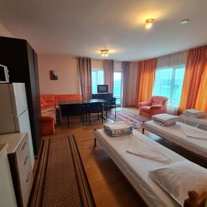 Zimmer mit Betten und einem Wohnzimmer mit Tisch in der Unterkunft Office Center and Showroom in Burgas City