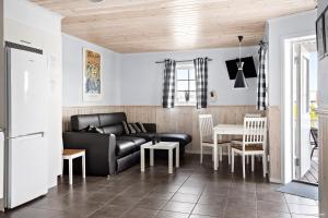 uma sala de estar com um sofá preto e uma mesa em First Camp Sunne - Fryksdalen em Sunne