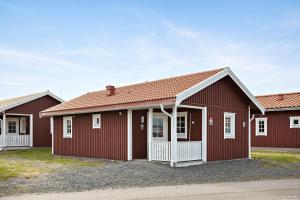 a row of red buildings with white windows at First Camp Sunne - Fryksdalen in Sunne