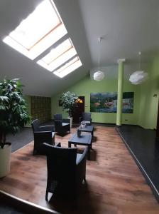 a lobby with chairs and tables and a skylight at Willa Wiekowa Sosna in Zalesie Górne