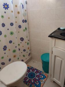 y baño con aseo y cortina de ducha. en CASA DE TOTAL DESCANSO Y SEGURIDAD, en Canelones