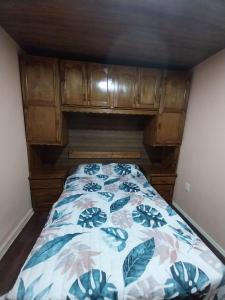 Dormitorio pequeño con cama con edredón de flores en CASA DE TOTAL DESCANSO Y SEGURIDAD, en Canelones